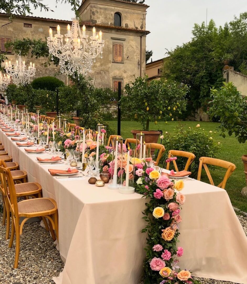 A long table with chairs and flowers on it