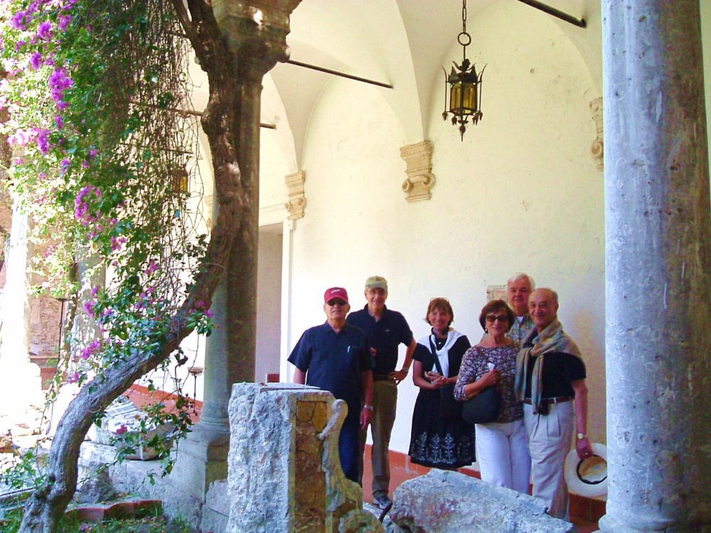 A group of people standing in front of an arch.