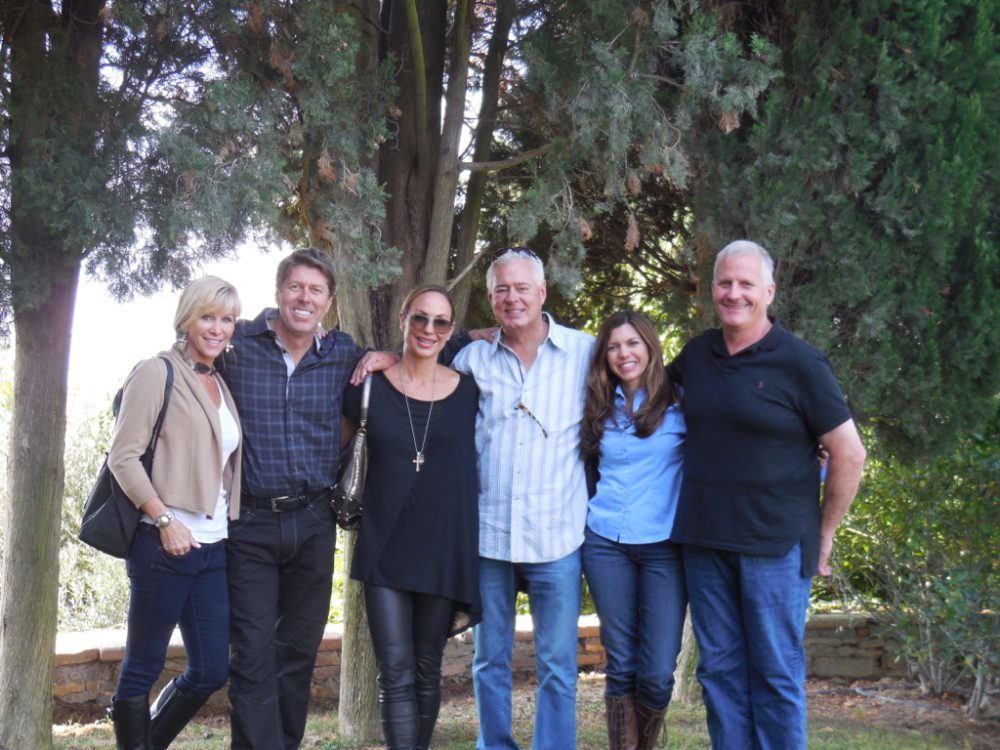 A group of people standing next to each other under a tree.