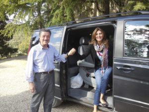 A man and woman standing in the back of an suv.