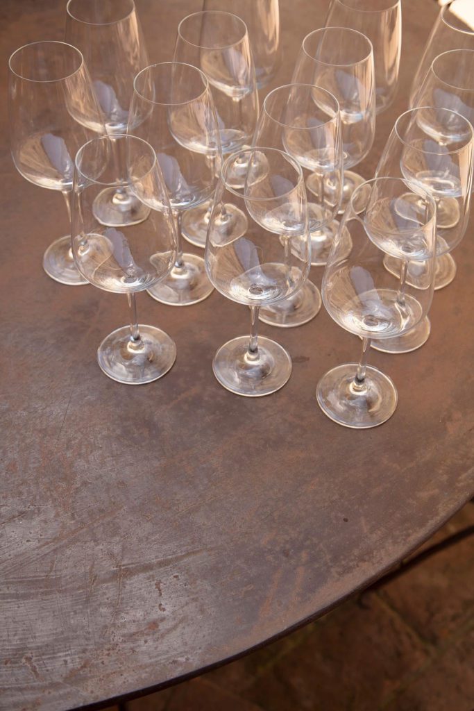 A table with many wine glasses on it